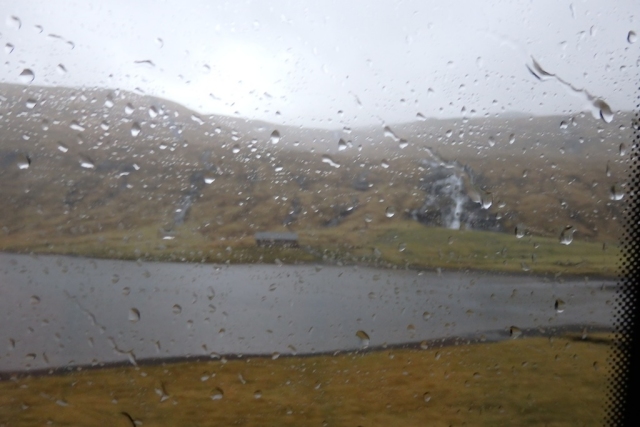 Rainy waterfall by a fjord
